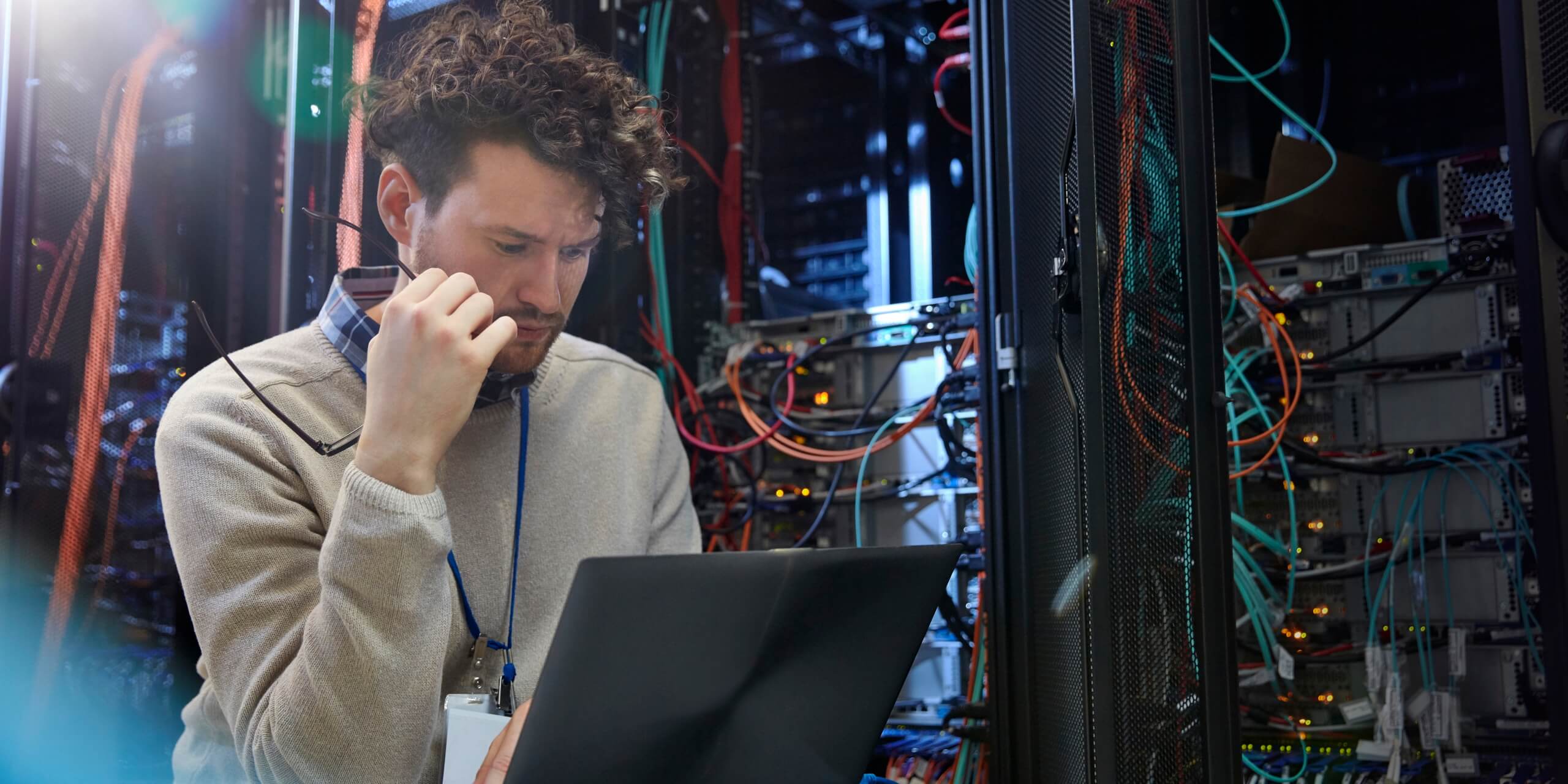 header image showing man looking at laptop in a data center